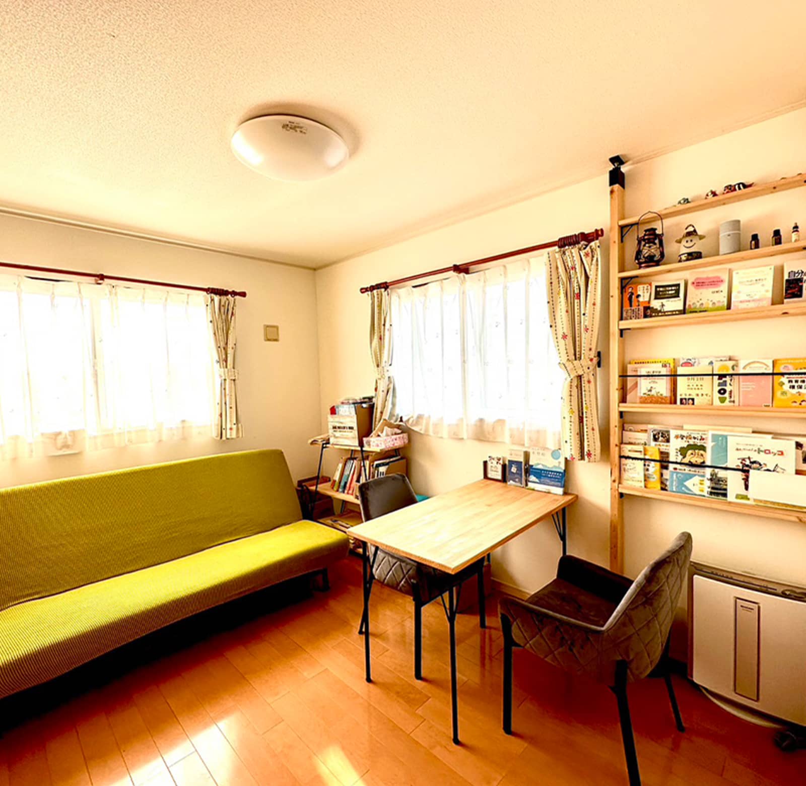緑色のソファーと木製のテーブルが置かれた室内